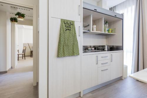 a kitchen with white cabinets in a room at Villa Cavalletti Appartamenti in Grottaferrata