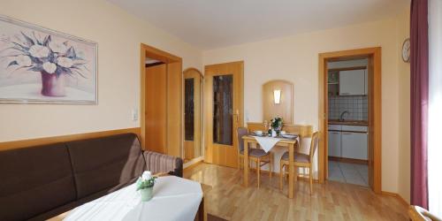 een woonkamer met een bank en een tafel bij Appartementhaus Safferstetten in Bad Füssing