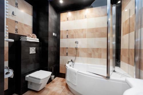 シュチェチンにあるSAS Apartamenty Amberのバスルーム(バスタブ、トイレ、シャワー付)
