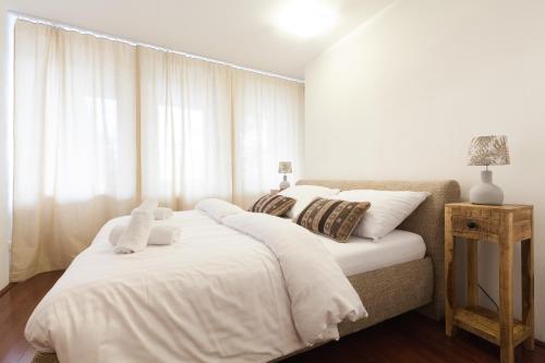 - une chambre dotée d'un grand lit avec des draps et des oreillers blancs dans l'établissement Apartment SnowWhite, à Starý Smokovec