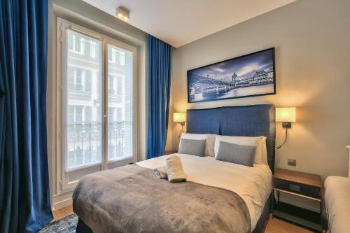 une chambre avec un grand lit et une fenêtre dans l'établissement 75 - Paris Assas Flat, à Paris