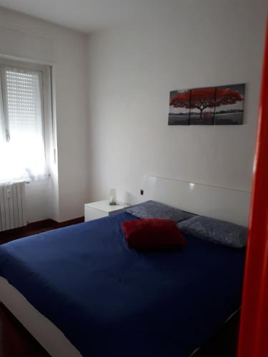 Un dormitorio con una cama azul y una ventana en Valassina milano apartment, en Milán