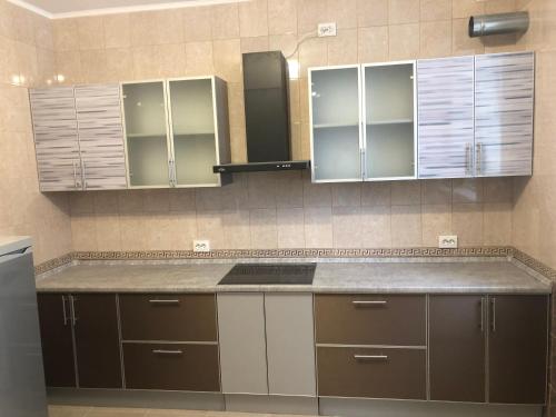a kitchen with brown cabinets and a counter top at Deliki Hostel in Kubinka