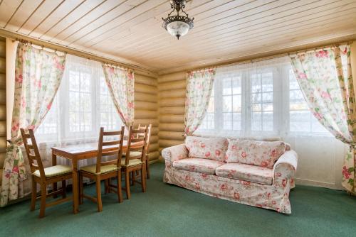 uma sala de estar com um sofá, uma mesa e cadeiras em Eco Hotel Noviy Kovtcheg em Gorodets