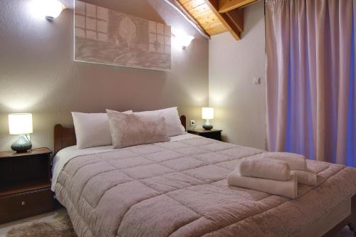 a bedroom with a large bed with two lamps at Tsironis Guesthouse in Ioannina