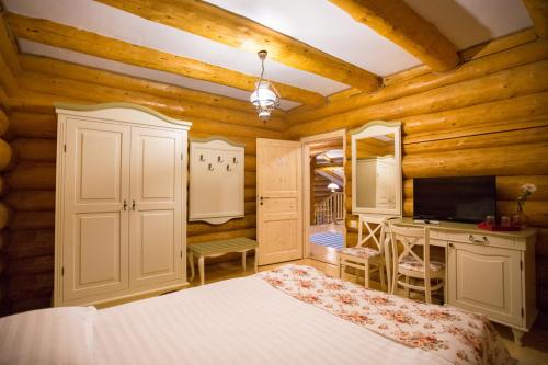 Schlafzimmer mit einem Bett, einem Schreibtisch und einem TV in der Unterkunft Conacul Maria Theresa in Orlat