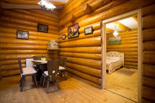 a room with a table and a bed in a log cabin at Conacul Maria Theresa in Orlat