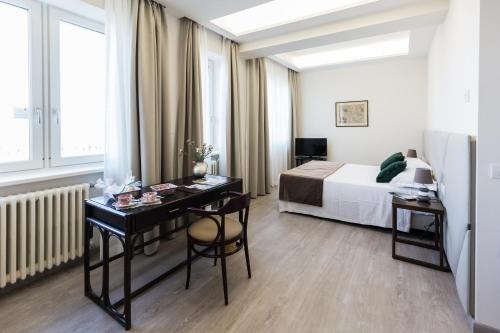 een hotelkamer met een bed en een bureau en een bed bij Villa Cavalletti Appartamenti in Grottaferrata