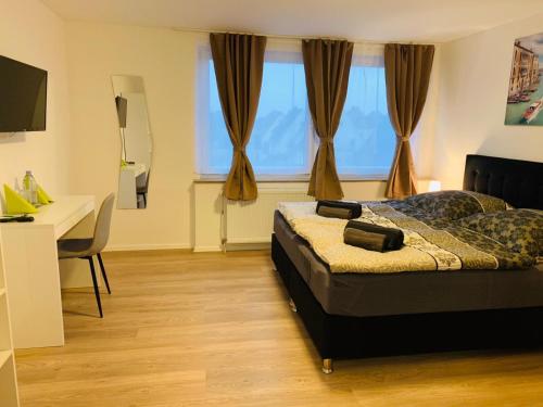 a bedroom with a bed and a desk and a window at Checkinn Hotel in Bad Salzuflen