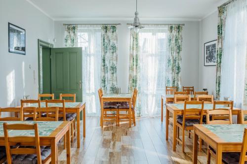a dining room with wooden tables and chairs at Villa Sopocka in Sopot
