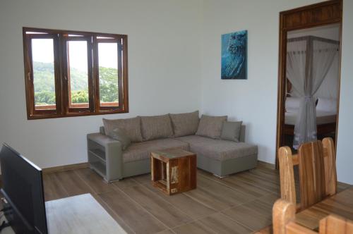 a living room with a couch and a table at La Perle Appartements in Baie Lazare Mahé