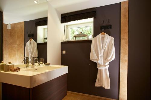 a bathroom with a sink and a mirror at Les Chambres de l'Oustalet, Chambres d'hôtes et Restaurant étoilé in Gigondas