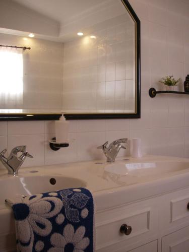 a bathroom with a sink and a mirror at Monte da Ria Guest House in Faro