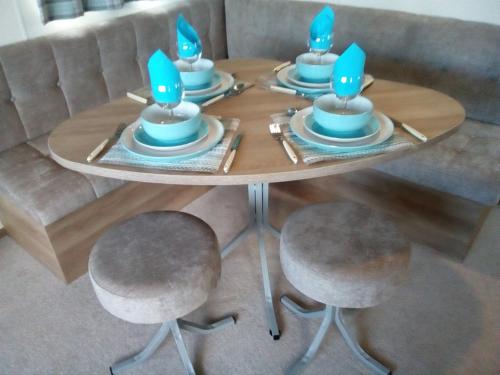 een ronde tafel met blauwe kaarsen erop bij Premium Accomodation with Hot Tub, Tattershall Lakes Country Park in Tattershall
