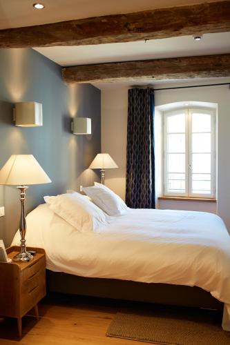 a bedroom with a large white bed and a window at Les Chambres de l'Oustalet, Chambres d'hôtes et Restaurant étoilé in Gigondas