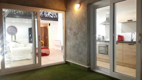 une cuisine avec des portes coulissantes en verre menant à un salon dans l'établissement " Les Lofts de Mérigonde ", à Castres