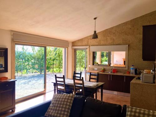 eine Küche und ein Wohnzimmer mit einem Tisch und Stühlen in der Unterkunft Quinta do Pêso in Amarante