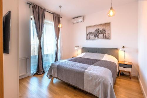 a bedroom with a bed and a large window at Central Apartment in Bucharest