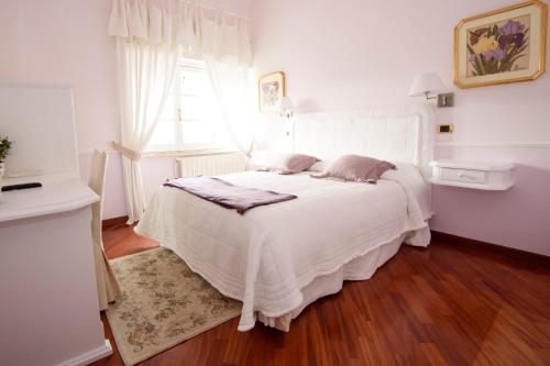 ein weißes Bett in einem Zimmer mit Fenster in der Unterkunft Calycanto in Tempio Pausania