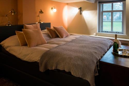 a bed with pillows on it in a room with a window at De Buren in Vleuten