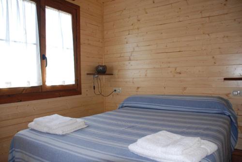 1 dormitorio con 1 cama con 2 toallas en La Facera, Cabañas de Madera, en Valparaíso