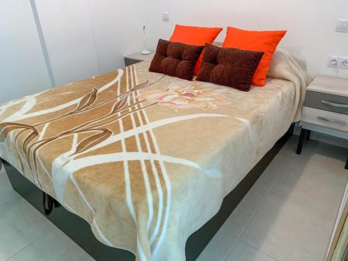 マスパロマスにあるApartamento Luxuryのベッド(オレンジの枕、花付)