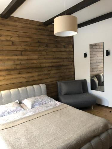 a bedroom with a bed and a chair at Girske Povitria 2 in Yaremche