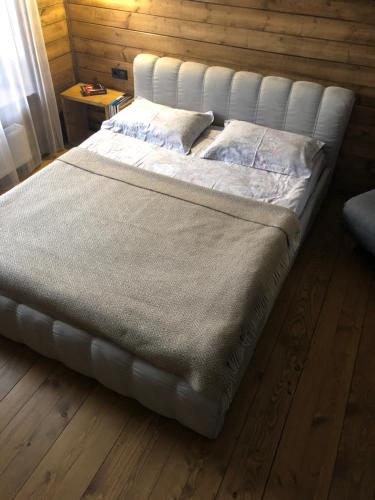 a large bed in a room with a wooden floor at Girske Povitria 2 in Yaremche