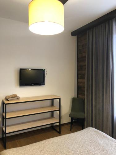 a bedroom with a bed and a tv on a wall at Girske Povitria 2 in Yaremche