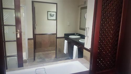 a bathroom with a sink and a mirror at Traders Guesthouse at Lake Pleasant Living in Sedgefield