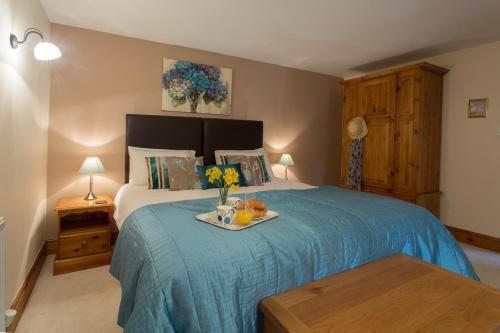 Un dormitorio con una cama y una bandeja con flores. en Callestock Courtyard Cottages, en Truro