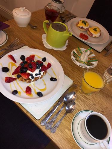 a table with a plate of food with fruit on it at St John's Lodge incl off-site leisure club in Windermere