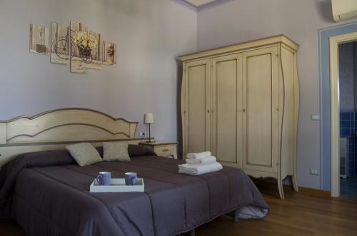 a bedroom with a bed with towels and a cabinet at Locanda Corte Roveri in Bologna