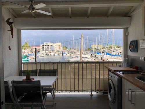 圣弗朗索瓦LES MARINES KAZATIBO的厨房设有可欣赏海港景色的窗户