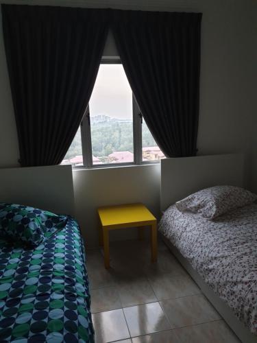 a bedroom with a bed and a table and a window at 5-Bedroom Family Apartment in Seri Kembangan
