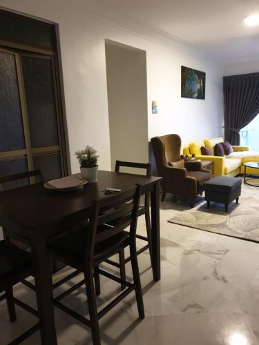 a living room with a table and chairs and a couch at 5-Bedroom Family Apartment in Seri Kembangan