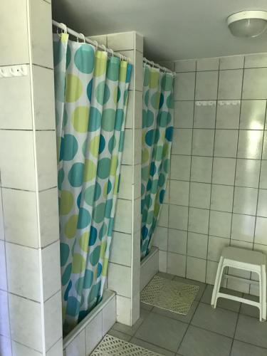 a shower curtain in a bathroom with a stool at Oliver Inn Camping in Balatonlelle