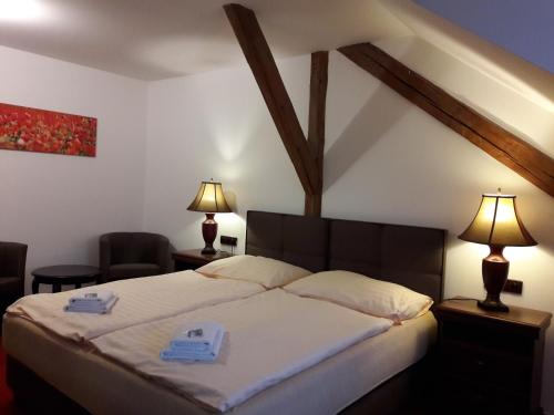 ein Schlafzimmer mit einem Bett mit zwei Handtüchern darauf in der Unterkunft Hotel Fogl in Nová Bystřice