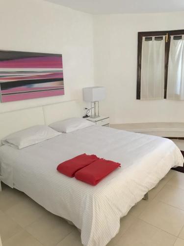 a white bed with a red towel on it at CALA BLANCA-TORRE BELLVER in Cala Blanca