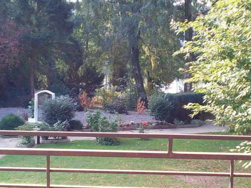 a wooden bench in a park with a garden at Hotel Seehaus in Horn-Bad Meinberg