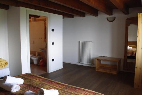 1 dormitorio con paredes blancas, suelo de madera y 1 cama en Trentino in malga: Malga Zanga, en Arco