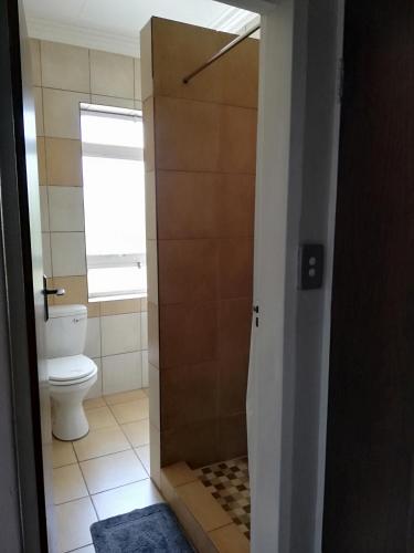a bathroom with a toilet and a shower stall at The Shakespeare Inn in Vanderbijlpark