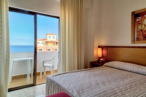 een slaapkamer met een bed en uitzicht op de oceaan bij Hotel Marquesa in Puerto de la Cruz