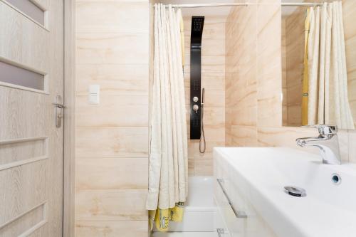 a bathroom with a sink and a shower at Cozy Apartments by Renters in Świnoujście