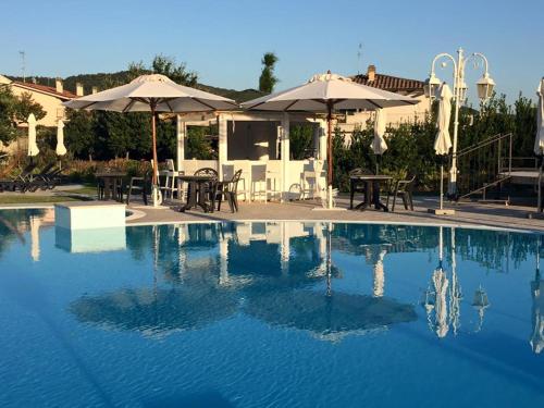 博爾塞納的住宿－Hotel Columbus sul Lago，一个带桌子和遮阳伞的游泳池