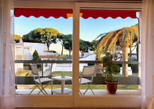 una ventana con vistas a un patio con mesa y sillas en Residencia Beach en Cambrils