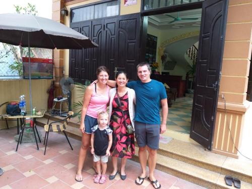 a family poses in front of a house at Lys Homestay in Ninh Binh