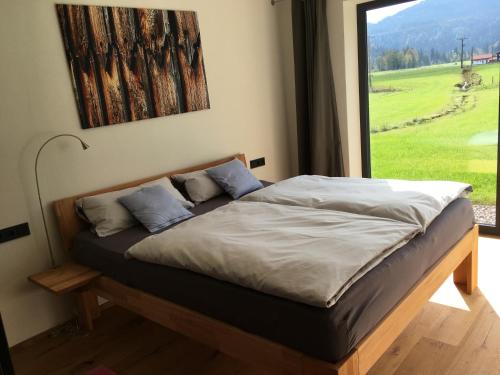 a bed in a room with a large window at Ferienwohnung Berglieb in Oberstdorf