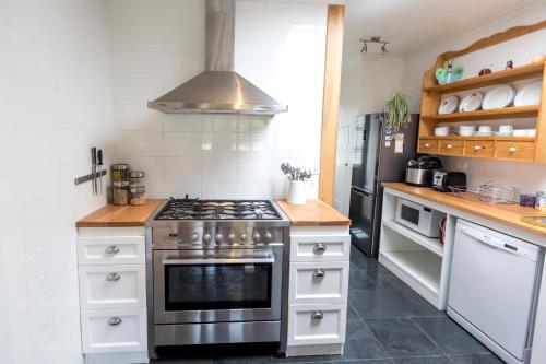 a kitchen with a stove and a refrigerator at Puerto Bories House, holiday home rentals in Patagonia in Puerto Natales
