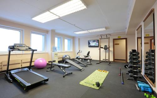 a gym with several treadmills and equipment in a room at Park Tower in Moscow